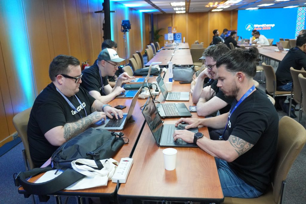 A group of developers working on laptops together during WordCamp Asia 2025 Contributor Day.